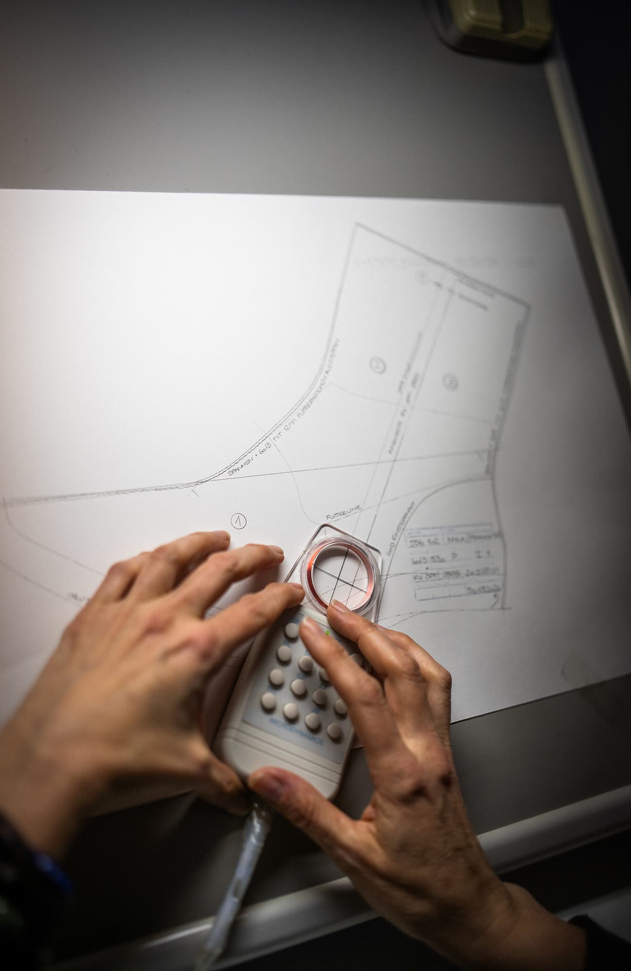 Mains travaillant sur une forme avec un dessin technique