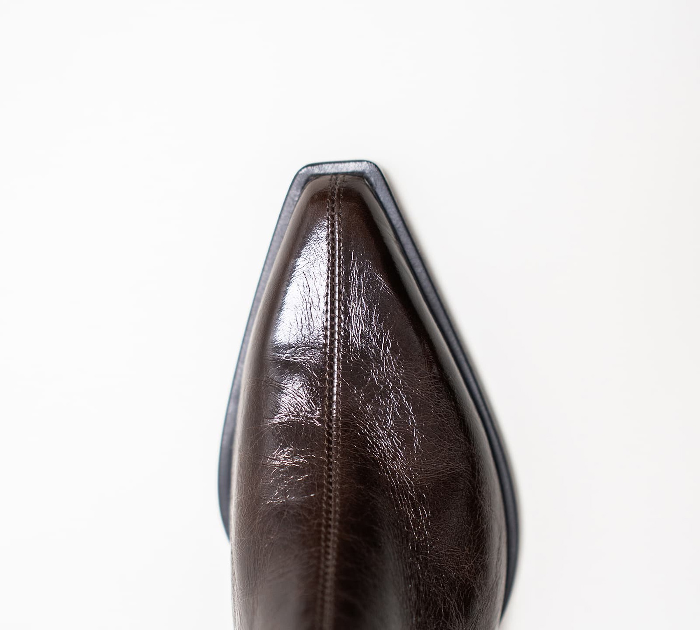 Spitze einer Stiefelette aus braunem Lackleder