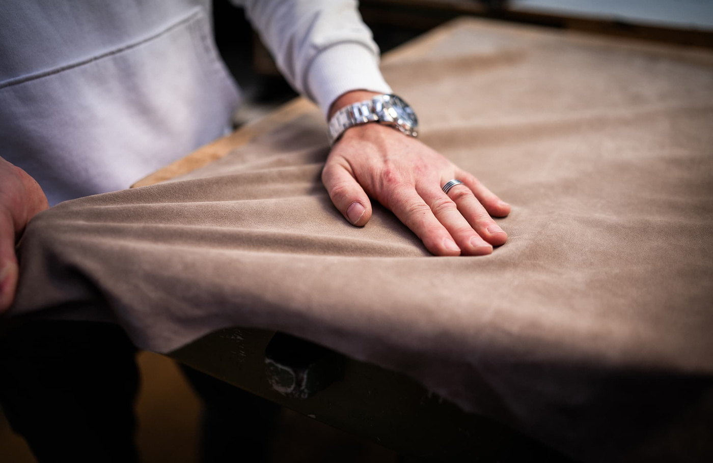 Main découpant du cuir sur la table de coupe